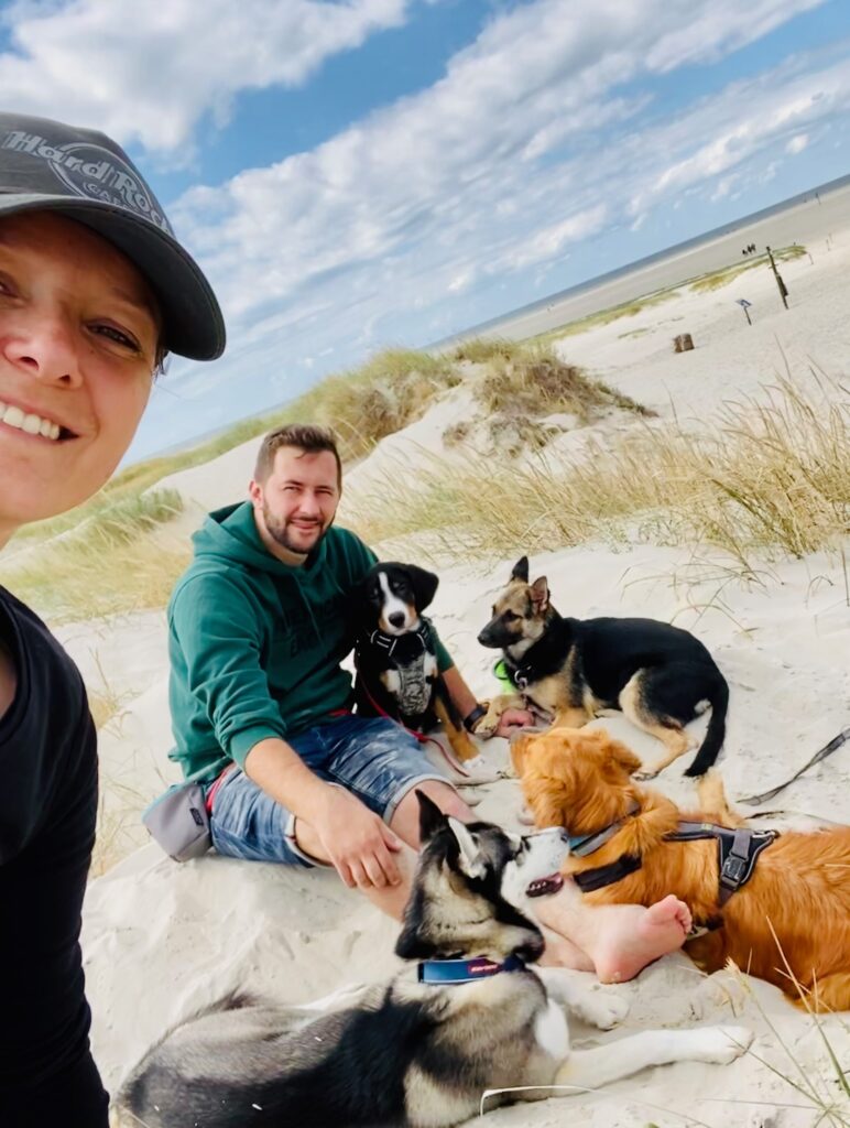 Christin und Tobi mit vielen Hunden am Strand